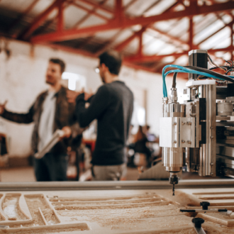 a machine with a workers in the background