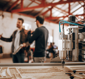 a machine with a workers in the background