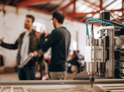 a machine with a workers in the background